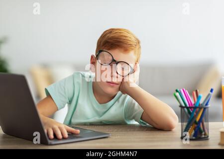 Il ragazzo esausto si addormentò mentre stava facendo i compiti Foto Stock