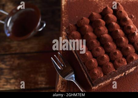 Da sopra di un delizioso dessert Tiramisù servito in tavola di legno con forchetta Foto Stock