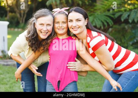 Ritratto di sorridente nonna caucasica con figlia e nipote adulta in giardino Foto Stock