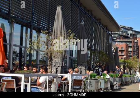 NEWCASTLE. TYNE e USURA. INGHILTERRA. 06-24-21. Il Quayside dalla Tyne, i clienti si sono seduti fuori di un bar per aiutare con le norme di distanziamento sociale. Foto Stock