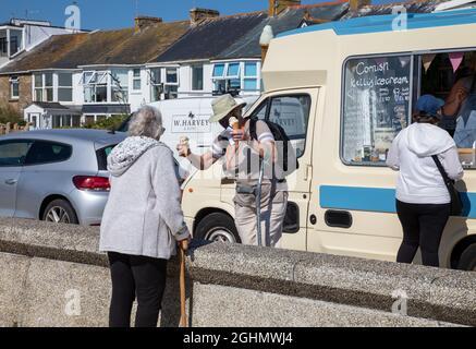 Penzance, Cornovaglia, 7 settembre 2021, la gente gode del sole glorioso in Penzance, Cornovaglia in una giornata estremamente calda con 29C. Lungo il lungomare la gente camminava, si rilassava e si gustava un gelato dal furgone parcheggiato lungo la parte anteriore. Le previsioni meteo sono per le condizioni mutevoli nei prossimi giorni. Credit: Keith Larby/Alamy Live News Foto Stock