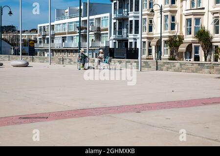 Penzance, Cornovaglia, 7 settembre 2021, la gente gode del sole glorioso in Penzance, Cornovaglia in una giornata estremamente calda con 29C. Lungo il lungomare la gente camminava, si rilassava e si gustava un gelato dal furgone parcheggiato lungo la parte anteriore. Le previsioni meteo sono per le condizioni mutevoli nei prossimi giorni. Credit: Keith Larby/Alamy Live News Foto Stock