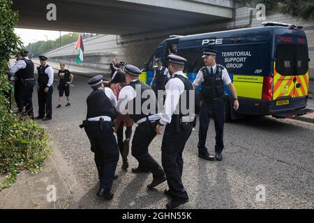 Londra, Regno Unito. 6 settembre 2021. Gli ufficiali della Metropolitan Police cercano di impedire ad un attivista per i diritti umani di correre su una strada di fronte ad un grande veicolo militare durante una protesta contro la fiera DSEI 2021 di Excel London. Il primo giorno di una settimana di proteste di Stop the Arms Fair al di fuori della sede di una delle più grandi fiere di armi del mondo è stato ospitato da attivisti che chiedevano il divieto delle esportazioni britanniche di armi in Israele. Credit: Mark Kerrison/Alamy Live News Foto Stock