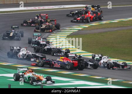 Sebastian Vettel (GER) Red Bull Racing RB8 sopravvive ad un crash con Sergio Perez (MEX) Sauber C31 e Bruno Senna (BRA) Williams FW34 al via della gara. 25.11.2012. Formula 1 World Championship, Rd 20, Gran Premio del Brasile, San Paolo, Brasile, Giorno di gara. Foto Stock