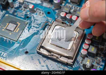 Primo piano composto termico su chip cpu nel computer della scheda madre Foto Stock