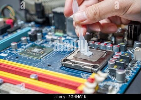 Primo piano composto termico su chip cpu nel computer della scheda madre Foto Stock