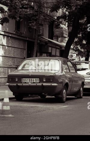 Foto in bianco e nero di una vecchia Opel vintage parcheggiata su una strada della città Foto Stock