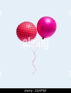 Due palloncini con corde che formano un cuore isolato su uno sfondo blu. Il concetto di San Valentino e l'amore. Layout rettangolo verticale. Minimo. Foto Stock