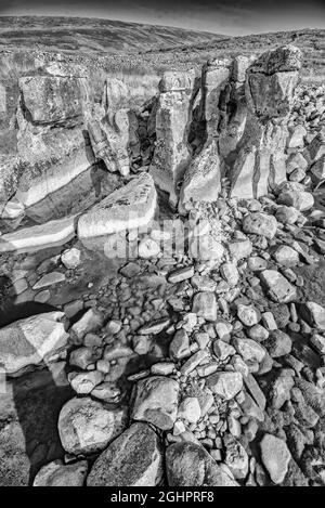 Winterscale beck è sotto le pendici di Whernside. Il becco era ad acqua molto bassa esponendo pilastri di pietra e un letto di macigno. Foto Stock