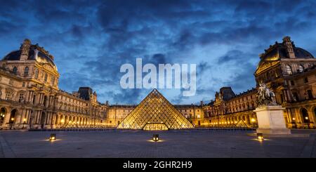 Panorama del museo e piramide del Louvre illuminata di notte a Parigi Francia Foto Stock