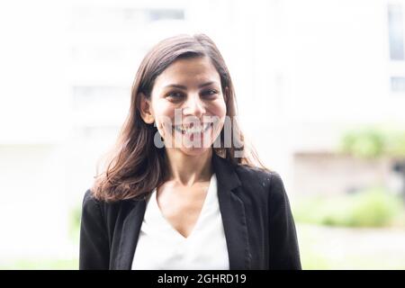 Direttore serio di mezza età in piedi fuori e ridendo, Friburgo, Baden-Wuerttemberg, Germania Foto Stock