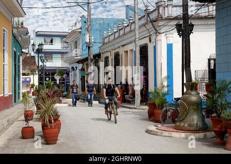 Scena di strada, Caraibi, persone, cubani, ciclisti e campane della Chiesa in Via della Campana, Calle Honorato, Città Vecchia, Sancti Spiritus, Centrale Foto Stock