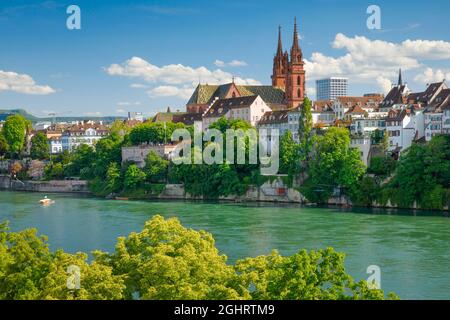 Vista della Cattedrale di Basilea nel centro della città vecchia di Basilea con il turchese fiume Reno in primo piano Foto Stock