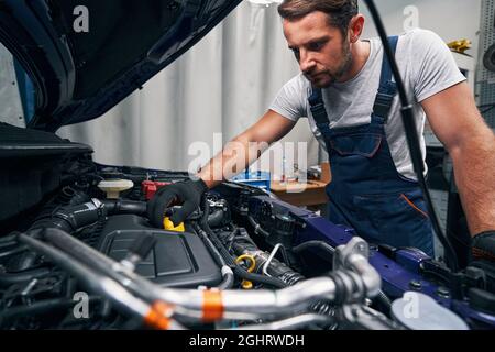 Il tecnico di riparazione apre la coppa dell'olio della vettura Foto Stock