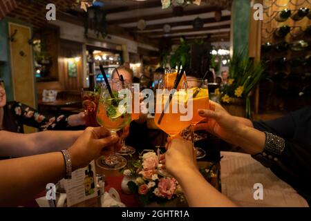brinda brindisi con i cocktail in un ristorante con gli amici. Foto Stock
