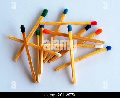 Primo piano di fiammiferi con teste di colori diversi su sfondo bianco. Foto Stock