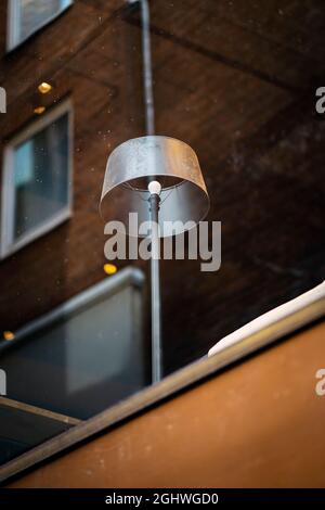 Lampada da terra che risplende attraverso una reliing coffee house finestra Foto Stock