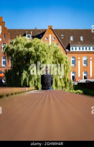 Uomo seduto sul bordo di un ormeggio Foto Stock