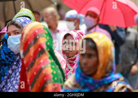 Dhaka, Bangladesh. 07 settembre 2021. La gente del Bangladesh attende in fila per acquistare beni essenziali dalla Trading Corporation of Bangladesh Truck a un tasso agevolato, a Dhaka, Bangladesh, settembre. La società di commercio statale del Bangladesh (TCB) vende tramite camion per fornire articoli essenziali tra le persone del gruppo a basso reddito a un prezzo agevolato in mezzo alla pandemia COVID-19. (Foto di Suvra Kanti Das/Sipa USA) Credit: Sipa USA/Alamy Live News Foto Stock