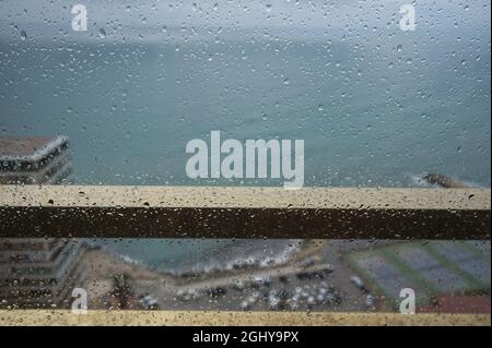 gocce di pioggia sul balcone dorato ringhiera con sfondo mare non focalizzato. vista Foto Stock