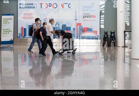 Mississauga, Canada. 7 Settembre 2021. I viaggiatori che indossano maschere facciali camminano attraverso la sala degli arrivi all'Aeroporto Internazionale Pearson di Toronto a Mississauga, Ontario, Canada, il 7 settembre 2021. Il Canada ha iniziato martedì a consentire l'ingresso per stranieri completamente vaccinati che hanno avuto un corso completo di un vaccino COVID-19 approvato da Health Canada. Credit: Zou Zheng/Xinhua/Alamy Live News Foto Stock