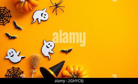 Felice Halloween concetto di vacanza. Decorazioni di Halloween, zucche, pipistrelli, fantasmi, pipistrelli su sfondo arancione. Halloween festa biglietto d'auguri mockup con c Foto Stock