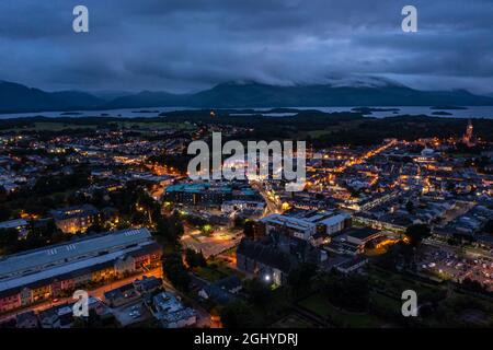 Vista aerea della panoramica cittadina turistica di Killarney nella contea di Kerry in Irlanda con luci accese sotto un cielo nuvoloso mattina presto sorgere Foto Stock