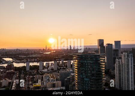 Vista panoramica aerea dello skyline di Londra est all'alba con grattacieli di Canary Wharf e un bel cielo colorato sullo sfondo Foto Stock