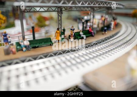 primo piano di piste, città, edifici e persone sul treno giocattolo set Foto Stock
