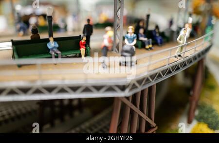primo piano di piste, città, edifici e persone sul treno giocattolo set Foto Stock