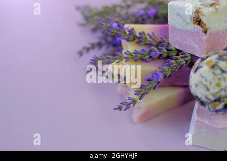 Lavanda bagno bombe e sapone, fiori di lavanda su uno sfondo viola chiaro.Spa e aromaterapia. Cosmetici vegetali biologici con estratto di lavanda Foto Stock