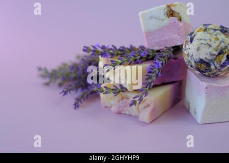 Lavanda bagno bombe e sapone, lavanda su sfondo viola chiaro. Spa e aromaterapia. Cosmetici vegetali biologici con extract.Beauty lavanda e. Foto Stock