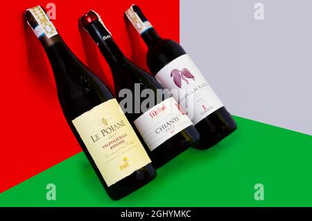 Bottiglie di vino inclinate, colori sfondo (rosso, bianco, verde) - Italia Foto Stock