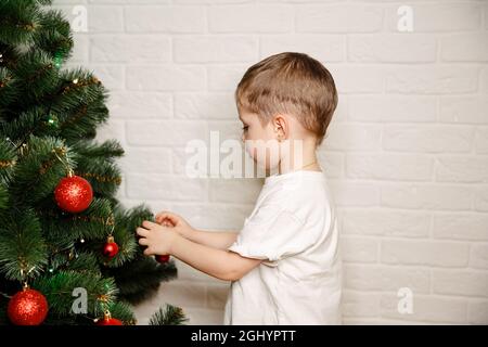 Preparazione di Natale. Famiglia decorazione albero di Natale con ornamenti Foto Stock