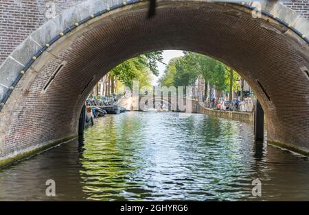 Amsterdam Paesi Bassi - Agosto 17 2017; fila di sette ponti ad arco in mattoni che spariscono in lontananza lungo il canale Reguliersgracht di Amsterdam. Foto Stock