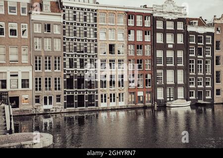 Amsterdam Olanda - Agosto 17 2017; architettura, scuderie e finestre con effetto fotografico del Vecchio mondo in file di colorati appartamenti iconici a Damrak in c. Foto Stock