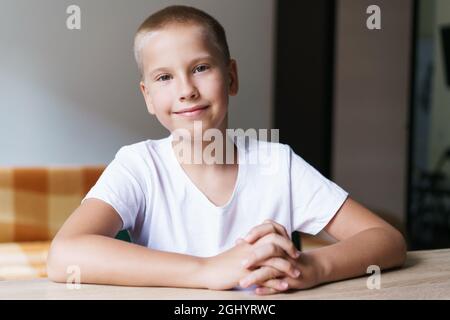 Ritratto di simpatico scolaro di z generazione in t-shirt bianca che parla con la webcam durante le videochiamate. I bambini studiano online, studiano a casa, utilizzando gadget per conversazioni virtuali con l'insegnante. Acquisizione schermata Foto Stock