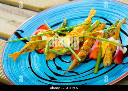 Acciughe in pastella con salsa e verdure Foto Stock