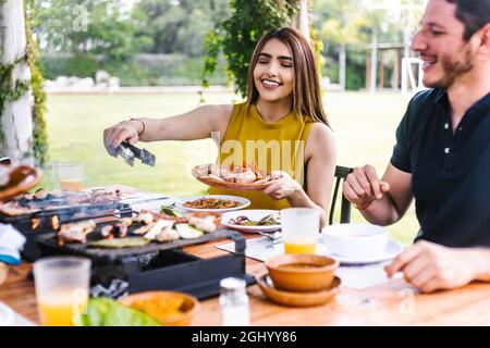 Coppia ispanica che mangia tacos e cibo messicano nella terrazza all'aperto del ristorante in Messico America Latina Foto Stock