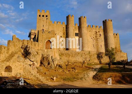 Obidos Castello incandescente arancione poco prima del tramonto a Obidos, Leiria, Portogallo Foto Stock