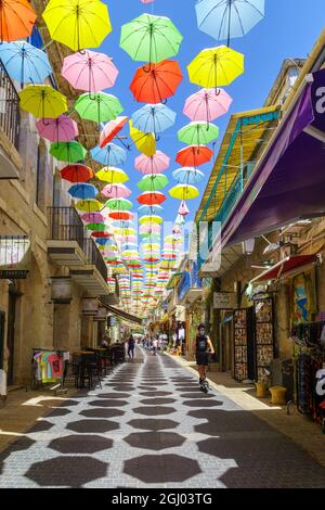 Gerusalemme, Israele - 30 agosto 2021: Pedoni e ombrelloni colorati, in via Yoel Moshe Solomon, lo storico vicino Nachalat Shiva Foto Stock