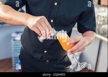Uomo barista cocktail mescolando con giocoliere versando su bicchiere di vino al bar sul tetto Foto Stock