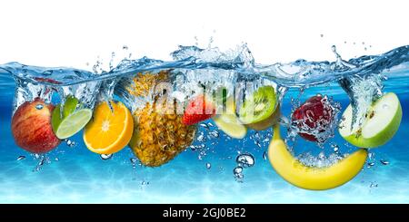 varie frutta fresca colorata e gustosa che si spruzza in acqua fredda isolata su sfondo blu bianco. dieta alimentare sano mangiare freschezza concetto Foto Stock