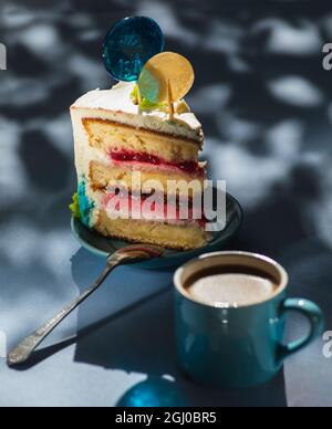 Piatto con fetta di gustosa torta fatta in casa sul tavolo, torta al lampone. Colourful lollipop swirl su bastone di legno Foto Stock