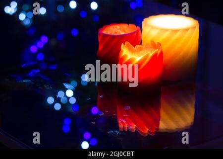 Bellissime candele aromatiche con luci blu bokeh sullo sfondo Foto Stock