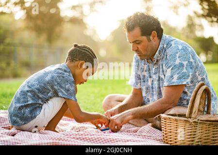 Padre che gioca con figlio su coperta Foto Stock