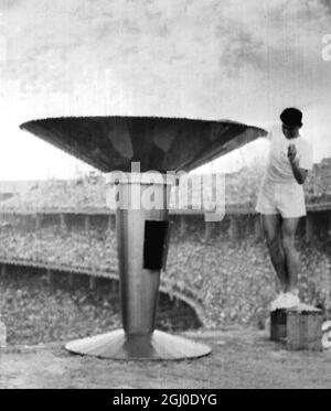Melbourne Olympic Games 1956 la torcia olimpica, portata da Ron Clarke in Australia, è immersa nell'Urn olimpico per illuminare la fiamma simbolica durante la cerimonia di apertura della XVI Olympiade al Melbourne Cricket Ground. 22 novembre 1956 Foto Stock