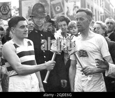 H J Bignall (a destra) consegna della torcia olimpica a Fred Prevett a Redhill, Surrey durante il progresso delle fiamme da dover a Wembley, Londra per la cerimonia di apertura dell'Olympias. 26 LUGLIO 1948 NON DESTINATO ALLA RIPRODUZIONE ESCLUSIVAMENTE PER USO PRIVATO Foto Stock