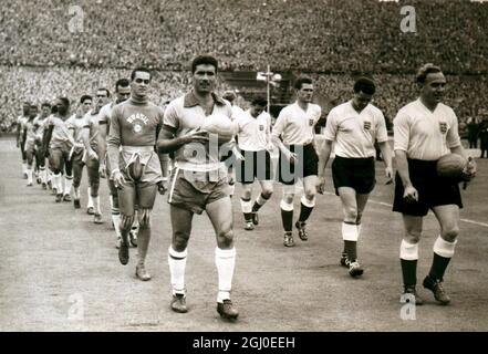 Inghilterra contro Brasile le squadre brasiliane e inglesi camminano sul campo allo stadio di Wembley, Londra, per il loro primo completo scontro internazionale in Inghilterra dalla guerra. Guidato dai loro capitani S. Nilton (a sinistra) e Billy Wright. L'Inghilterra ha vinto il 4-2 9 maggio 1956 Foto Stock