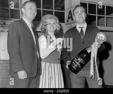 Il capitano della squadra di calcio del Chelsea Ron Harris e il manager della squadra del Chelsea Tommy Dochrety ricevono una bottiglia gigante di champagne da Edith Hood di Fulham, che lavora per il mercante di vino che l'ha presentata. 19 maggio 1967. Foto Stock